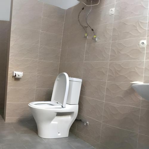 a bathroom with a toilet and a sink at Jambo Guest House in Taba