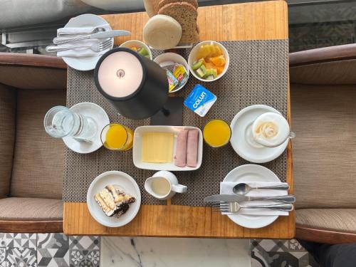 a table with breakfast food and drinks on it at Laura del Mar Hotel Boutique in Concón