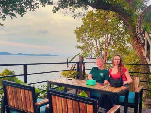 ロンサレム島にあるThe Cliff Hostel, M'Pay Bayの水辺のテーブルに座る二人の女性