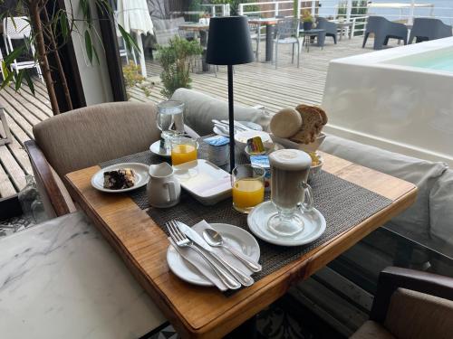 a table with a tray of breakfast food on a balcony at Laura del Mar Hotel Boutique in Concón