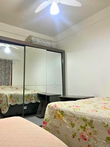 una camera da letto con due letti e uno specchio di Apartamento mobiliado em Florianópolis a Florianópolis