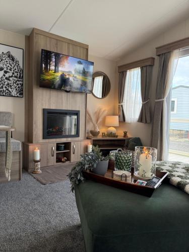 a living room with a couch and a tv at Luxury Caravan, On the beach in Redcar