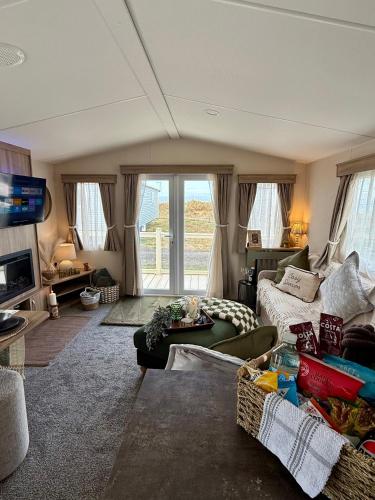 a living room with a couch and a tv at Luxury Caravan, On the beach in Redcar