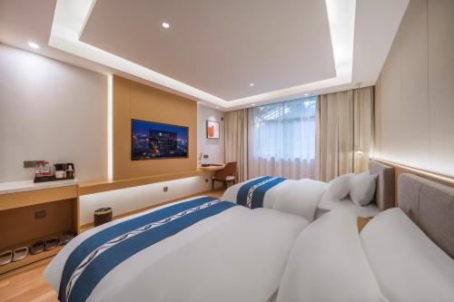 een hotelkamer met twee bedden en een raam bij Wanxin Zhige Hotel in Zhangla