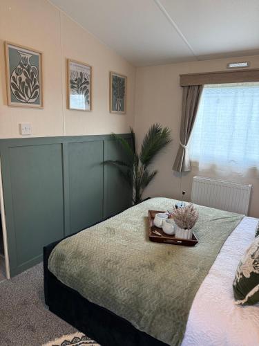 a bedroom with a bed with a tray on it at Luxury Caravan, On the beach in Redcar