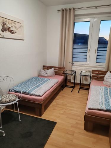 a room with two beds and a table and windows at Elbe Quartier Meissen TOP MONTEURUNTERKÜNFTE Wohnung 12 in Meißen