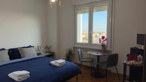 a bedroom with a bed and a table and a window at Alla Torre - Room & Private Bathroom in Treviso