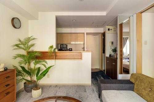 a living room with a couch and a kitchen at Cozy Stay Sapporo Central Nakajima in Toyohira
