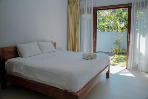 a bed with a stuffed animal on it in a bedroom at Padma Graha Villa in Candidasa