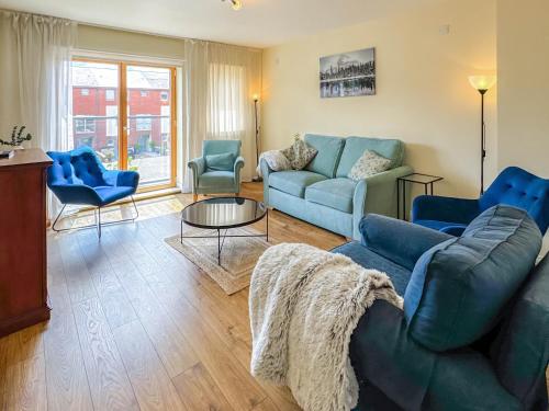 a living room with blue couches and chairs at Marina Escape in Swansea