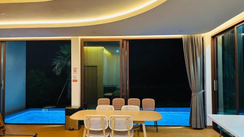 a dining room with a table and chairs and a pool at Sunrise Resort & Cafe - ซันไรส์ รีสอร์ท & คาเฟ่ in Nakhon Phanom