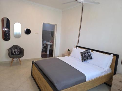 a bedroom with a large bed and a chair at SaltyNest in Gatunga