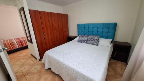 a bedroom with a bed with a blue head board at D14-9 Arriendo diario a pasos de la playa Arica in Arica