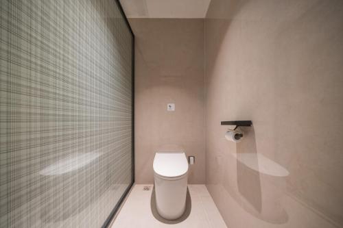 een badkamer met een wit toilet in een kamer bij Wanxin Zhige Hotel in Zhangla