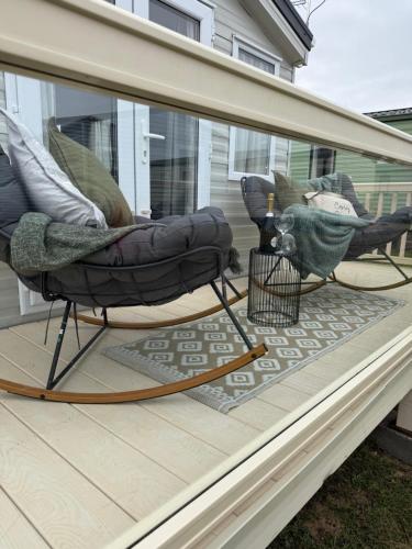 eine abgeschirmte Veranda mit zwei Stühlen und einem Sofa in der Unterkunft Luxury van at Redcar Beach in Redcar