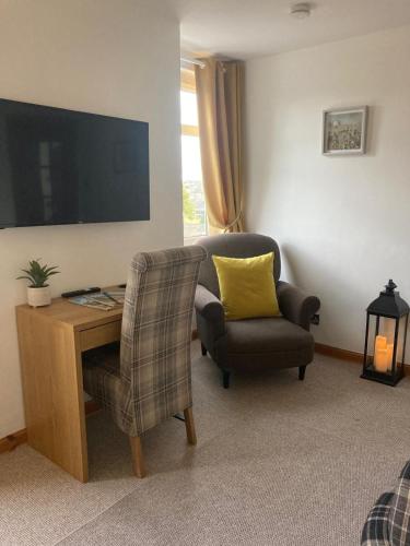 a living room with a desk and a chair and a television at Free Parking, Near Airport, Aberdeen Uni and ARI in Aberdeen