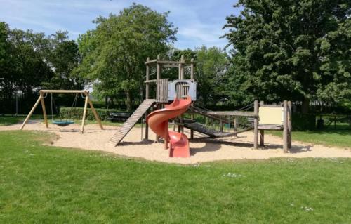a playground with a red slide in a park at Rekerlanden 187 in Schoorldam