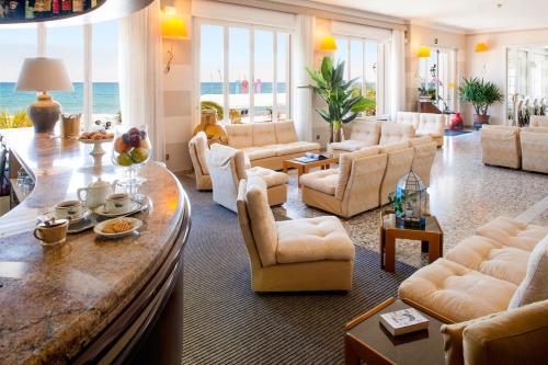 a living room with white furniture and the ocean at Hotel Golfo e Palme in Diano Marina