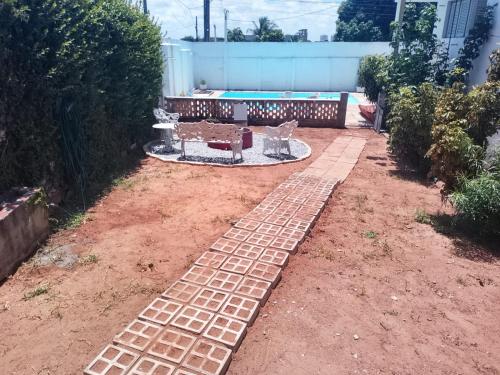 a garden with a brick path in the yard at Hostel La Casa de Mabel in Natal