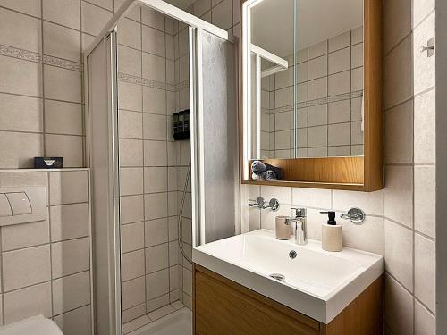 a bathroom with a sink and a mirror and a shower at Zentrale Oase, Ski, Berge Spass, 45m2, für 2P - C8 in St. Moritz