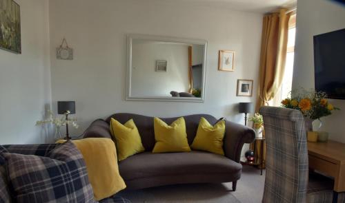 a living room with a couch with yellow pillows at Free Parking, Near Airport, Aberdeen Uni and ARI in Aberdeen