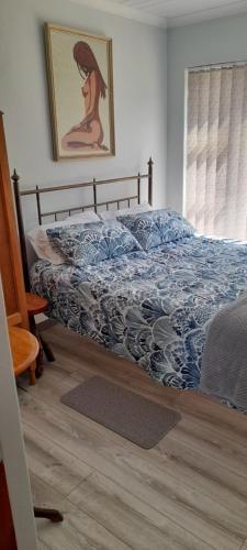 a bedroom with a bed with a blue comforter at 5 Cliff Street in Agulhas