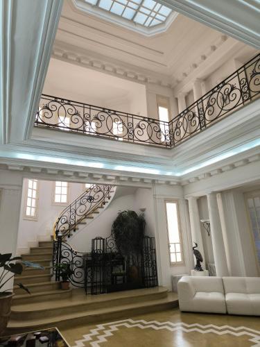 a large room with a staircase and a couch at Villa Meyer Demeure Remarquable chambre d'hôtes,Art Déco,standing in Béziers