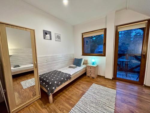 a bedroom with a bed and a mirror in it at Willa Avita in Karpacz