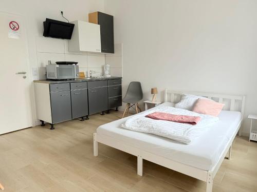 バート・エーンハウゼンにあるLoft am Kurpark, nähe Kurpark, GOP, Balitherme, mit Waschmaschine u Kücheのベッドルーム(白いベッド1台付)、キッチン