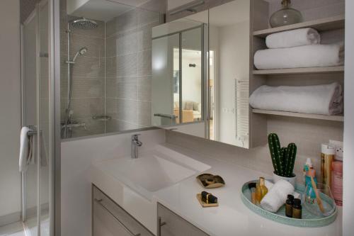 a bathroom with a sink and a mirror and towels at Domitys L'Ellipse in Paris