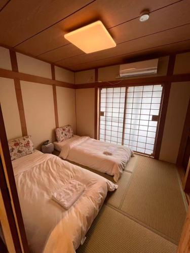 two beds in a room with two windows at 十分钟到达Namba in Osaka