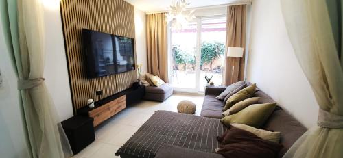 un soggiorno con divano e TV a schermo piatto di Apartman Cozy a Spalato (Split)