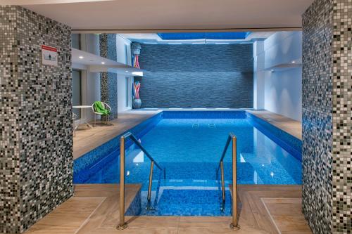 a swimming pool with blue water in a building at Domitys L'Ellipse in Paris
