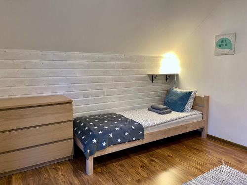 a bed in a room with a lamp and a dresser at Willa Avita in Karpacz