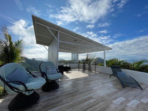 a covered deck with chairs and a table on a roof at Palco Pacífico Villa with Private Rooftop Pool in Alto del Monte