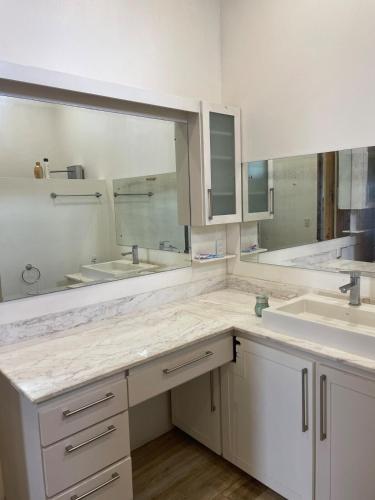 a bathroom with two sinks and two mirrors at Palco Pacífico Villa with Private Rooftop Pool in Alto del Monte
