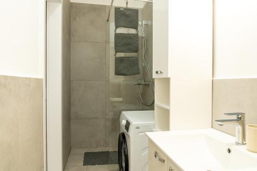 a bathroom with a shower and a washing machine at Urban NEST apartment - FREE Parking & Central in Kočevje