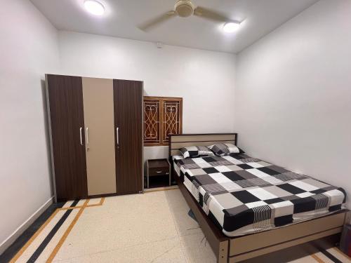 a bedroom with a bed with a black and white checkered at DNN Brothers Villa in Jaffna