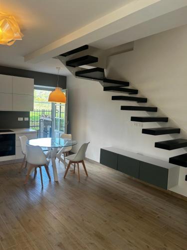 een woonkamer met een trap met een tafel en stoelen bij Casa Rachele in Arezzo