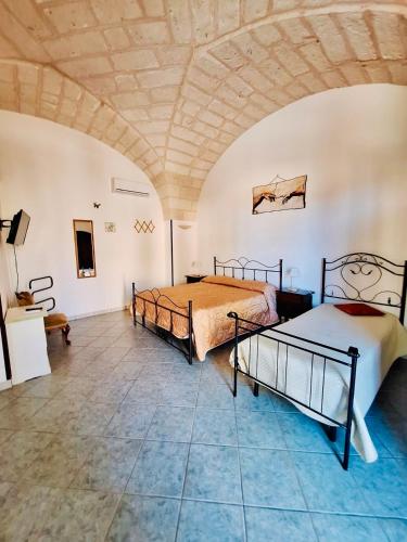 two beds in a room with a ceiling at Villa Papaleo B&B in Bagnolo del Salento