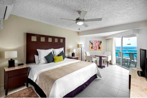 ein Schlafzimmer mit einem Bett und einem Balkon mit Meerblick in der Unterkunft El cid La ceiba beach in Cozumel