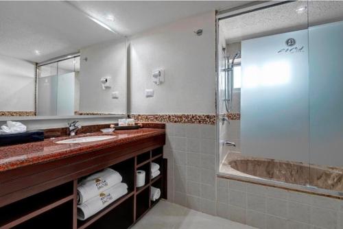 ein Badezimmer mit Dusche, Waschbecken und Badewanne in der Unterkunft El cid La ceiba beach in Cozumel