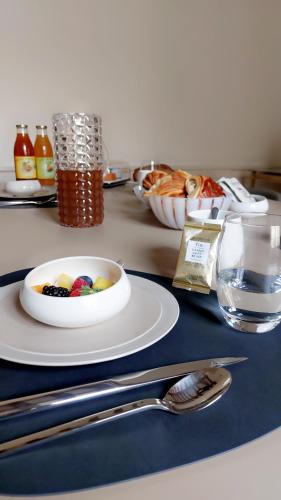een tafel met een schaal fruit op een bord bij La Demeure Saint Sauveur in Caen