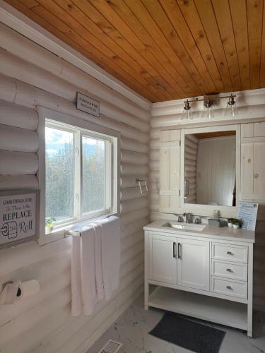 ein weißes Badezimmer mit Waschbecken und Spiegel in der Unterkunft Thanu Shack in Tobermory