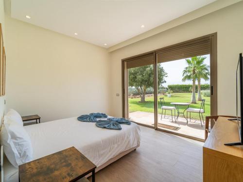 a bedroom with a bed and a sliding glass door at Sublime villa, piscine chauffée, petit déjeuner inclus in Sehib Foukani