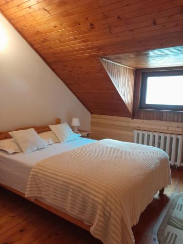 a bedroom with a large bed with a wooden ceiling at Vila Kira Buşteni in Buşteni