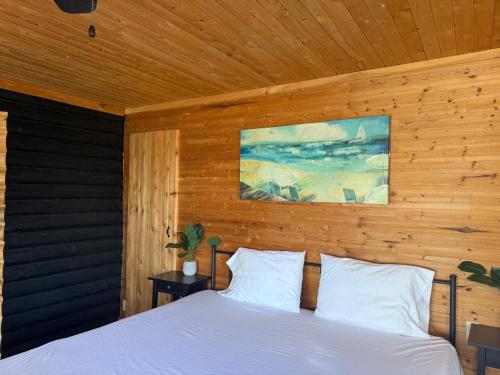 ein Schlafzimmer mit einem weißen Bett und einer Holzwand in der Unterkunft Thanu Shack in Tobermory