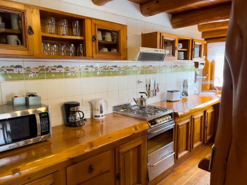 a kitchen with wooden cabinets and a stove top oven at ROTUI CABAÑA EXCLUSIVA DON FERMIN in San Martín de los Andes