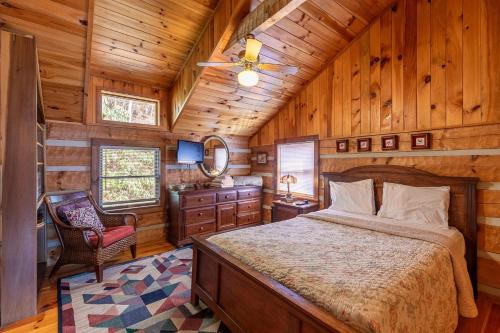 a bedroom with a bed and a chair in a cabin at Daniel Boone Lodge in Boone