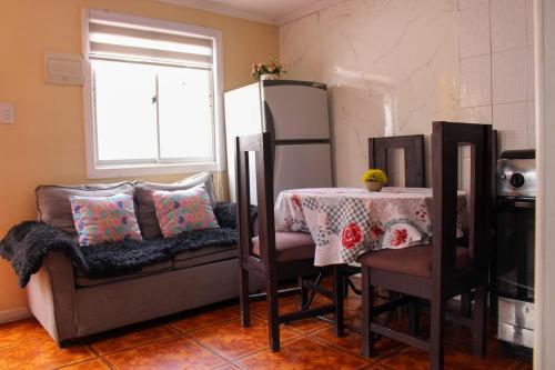 a living room with a table and a couch at Habitaciones Barrancas en San Antonio - Cabañas y Mini Departamentos in San Antonio